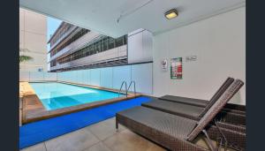 una piscina en medio de una habitación con silla en Apartments at Pandanus, en Darwin