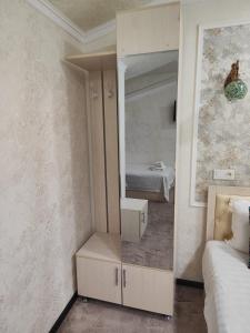 een slaapkamer met een spiegel en een bed in een kamer bij Hotel Suzani Samarkand in Samarkand