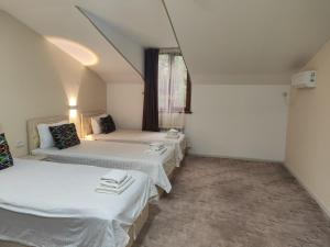 een kamer met twee bedden en een raam bij Hotel Suzani Samarkand in Samarkand