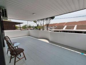 a balcony with a chair and a white wall at 23 Inn Kingbed Room with Balcony in Bukit Mertajam
