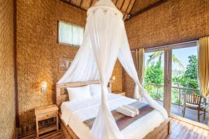 珀尼达岛艾杜森林小屋旅馆的带床和蚊帐的卧室