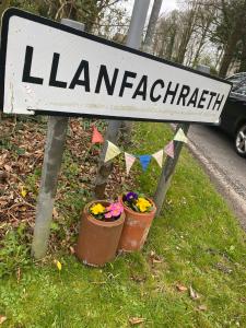 a street sign with two flower pots on the side of a road at Holland Hotel in Llanfachraeth