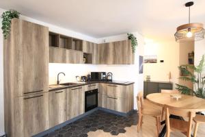 een keuken met houten kasten en een houten tafel bij Le Refuge Tropical Taine in Annecy +18 foto's