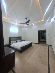 a bedroom with a bed and a ceiling fan at Haven homes in Islamabad