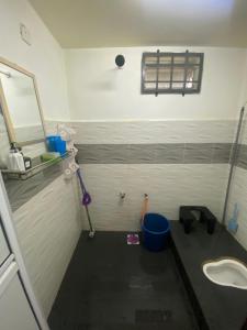 ein Badezimmer mit einem Mopp, einem Waschbecken und einem Spiegel in der Unterkunft Wan Homestay in Kuala Terengganu + 14 Fotos