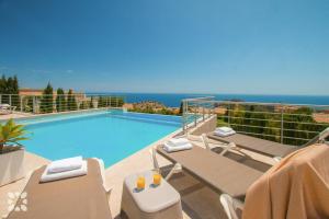 a swimming pool on a balcony with chairs and the ocean at Villa Punta Vista by Abahana Villas in Cumbre del Sol
