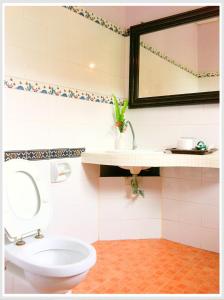 ein Badezimmer mit Toilette, Waschbecken und Spiegel in der Unterkunft The Emerald Krabi Beach Resort in Klong Muang Beach