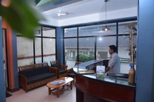 a man standing at a counter in a restaurant at Raahath Inn Munnar in Munnar