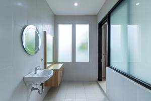 une salle de bain avec un lavabo et un miroir dans l'établissement Family Only Large Backyard Villa - De Reiz Kencana Syariah 4BR, à Ciburial