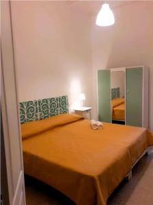 1 dormitorio con 1 cama grande de color naranja y espejo en Uwejja Boutique House Marsalforn seafront, en Marsalforn 2 fotos más