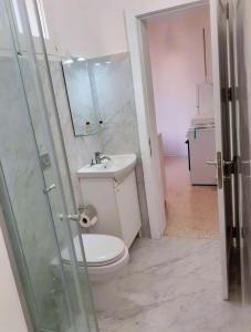 Un baño con inodoro, lavabo y ducha. en Uwejja Boutique House Marsalforn seafront, en Marsalforn