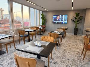 MelikgaziにあるPRIME INN CITYのテーブルと椅子、薄型テレビのあるレストラン