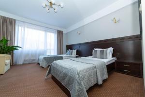 a hotel room with two beds and a window at Hotel Restaurant Alesia in Corunca
