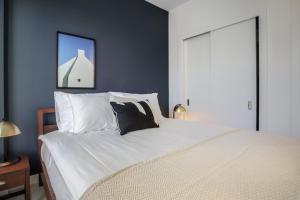 a bedroom with a large bed with white pillows at Rincon Hill 1BR w Gym Steam Room nr SVB FB SFO-208 in San Francisco +17 photos