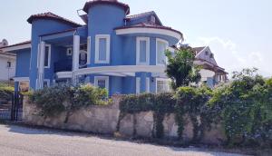 una casa azul con una valla delante en Villa Mavi Çalis, en Fethiye