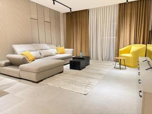 a living room with a couch and a yellow chair at Luxury Seaside Stay - SeaBreeze The Grand in Nardaran +9 photos