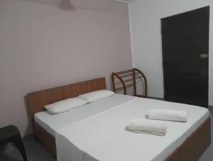 a bedroom with a bed with two towels on it at Gloria Cottage Non AC in Negombo