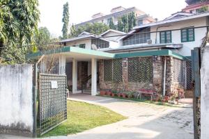 a house with a fence in front of it at The timeless Haven Heritage bungalow in Guwahati