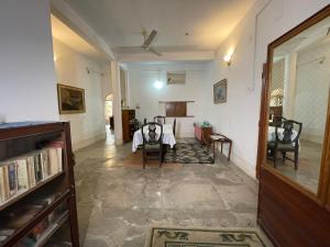 a living room with a table and chairs in it at The timeless Haven Heritage bungalow in Guwahati