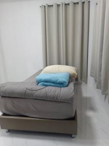 Una cama con dos almohadas encima en una habitación. en Small home, en Ban Khlong Hok Wa