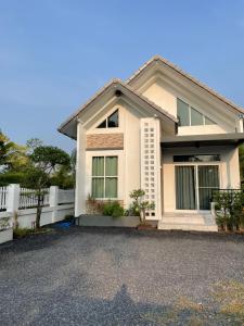 une maison blanche avec une clôture blanche dans l'établissement Small home, à Ban Khlong Hok Wa