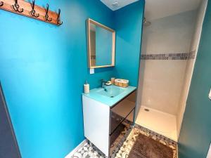a blue bathroom with a sink and a mirror at Studio Cosy LA CASA DE LENA in Bousies