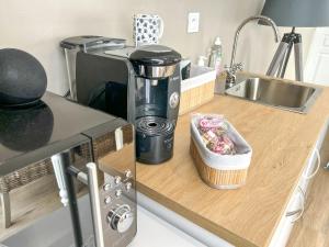 a kitchen counter with a coffee maker and a sink at Studio Cosy LA CASA DE LENA in Bousies