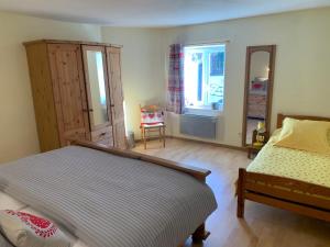 a bedroom with a bed and a dresser and a window at MAISON Cornimont in Cornimont