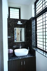 a bathroom with a white sink and a mirror at Providence homestay malpe in Udupi