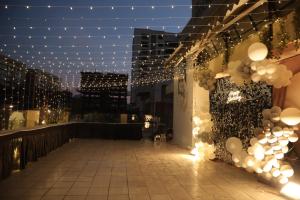 a rooftop patio with lights and balloons at night at Hotel Elegant inn in Surat