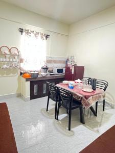 a kitchen with a table and chairs in a kitchen at Deivith Homestay Suite in Jowai +8 photos