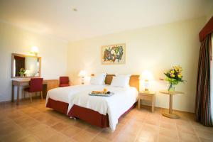 a hotel room with a bed with a tray of food on it at Mirachoro Carvoeiro in Carvoeiro