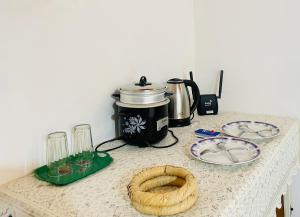 a table with a coffee pot and plates on it at Dhinuka villa in Weligama