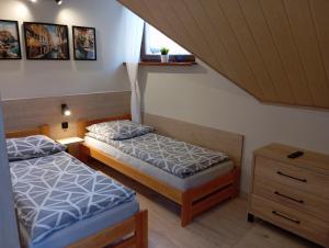 a bedroom with two beds and a window at Zacisze in Rozalin