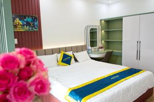 a bedroom with a bed with pink flowers in the foreground at Blue Diamond Homestay in Ấp Bình Phú