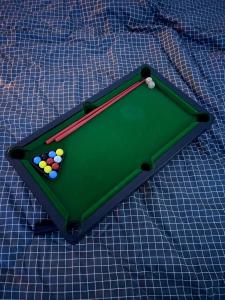 a green pool table with balls on top of a blanket at Cozynest Homestay n Cinema in Ho Chi Minh City