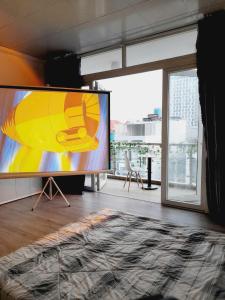 a large screen in a room with a large window at Cozynest Homestay n Cinema in Ho Chi Minh City