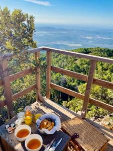 une table avec de la nourriture et des boissons sur un balcon dans l'établissement Cocoon Village, à Porto-Vecchio