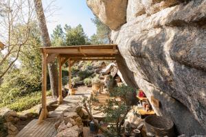 une passerelle en bois avec un mur en pierre dans l'établissement Cocoon Village, à Porto-Vecchio
