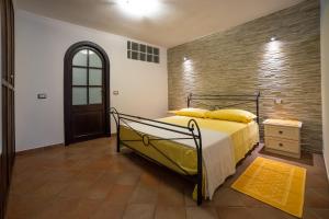 a bedroom with a bed and a brick wall at Casa Spiga in Cagliari
