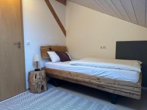 a bedroom with a bed with a wooden frame at Ferienwohnung Heuboden in Reut