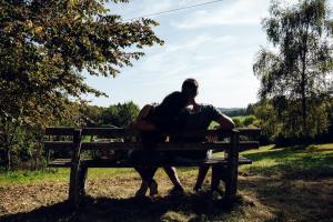 a man and a woman sitting on a park bench at Ferienwohnung Heuboden in Reut