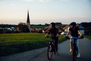 two men riding their bikes down a road at Ferienwohnung Heuboden in Reut