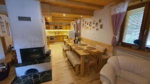 a living room with a long table and a fireplace at Chata Romeo in Harmanec