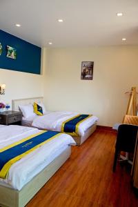 a hotel room with two beds and a chair at Blue Diamond Homestay in Ấp Bình Phú