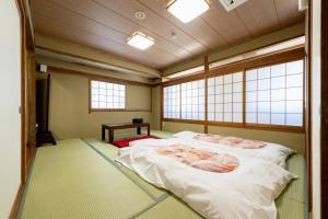 Postel nebo postele na pokoji v ubytování Hotel Matsumoto Yorozuya