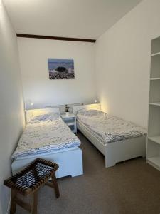 Una habitación con dos camas y un banco en ella. en 12 Ferienwohnung Familienzeit, en Burg auf Fehmarn
