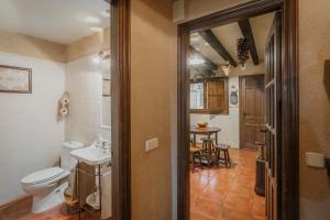 a bathroom with a toilet and a sink and a table at El Mirador De La Pinilla in Turrubuelo +23 photos