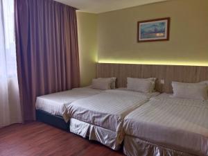 Postel nebo postele na pokoji v ubytování Gaya Centre Hotel