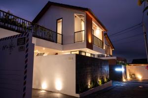 a white house with lights on the side of it at Sudut Padi Villa Ubud by Omkara Experience in Ubud